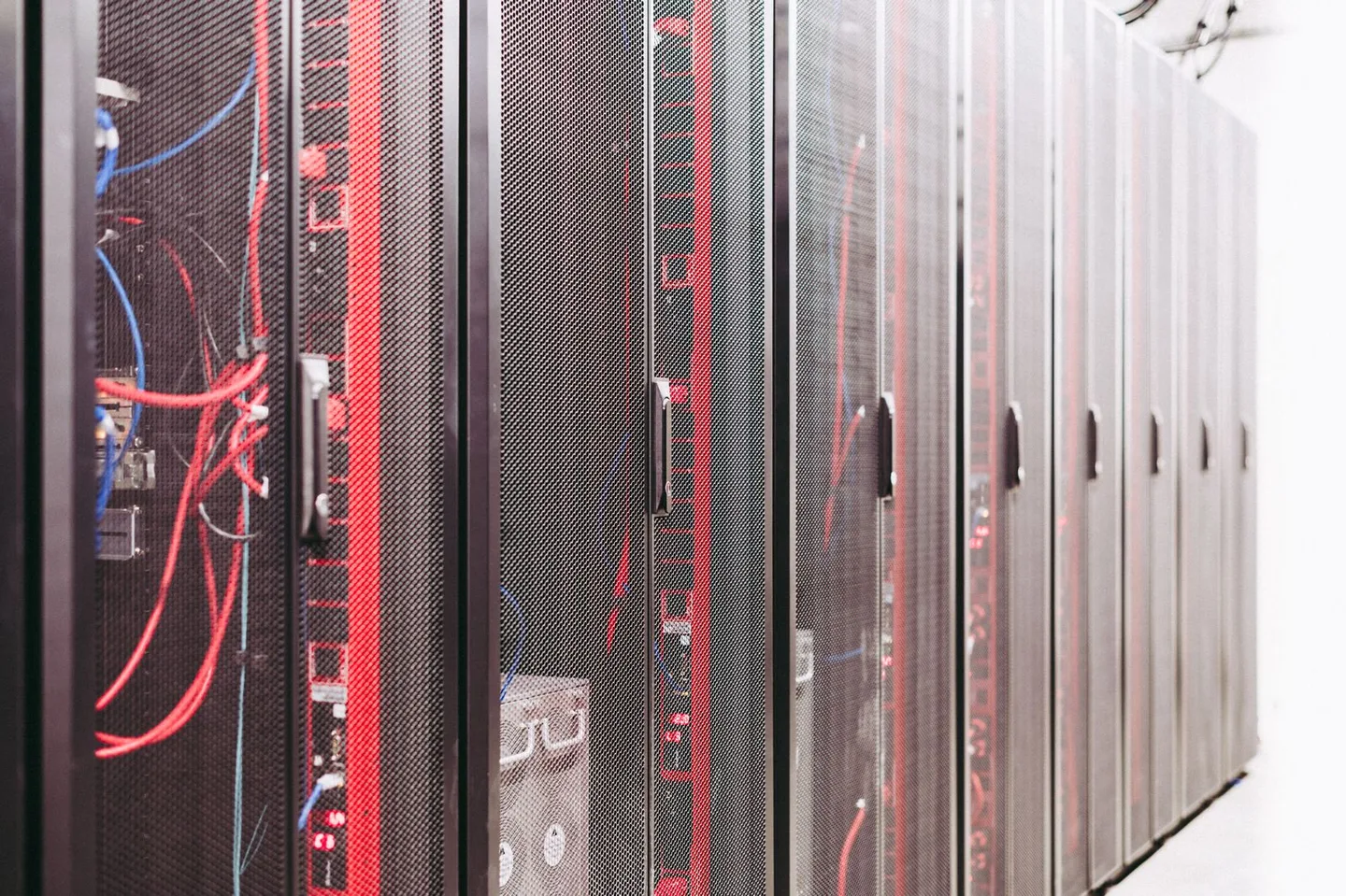 Server cabinets with network cables and indicator lights in a data center.